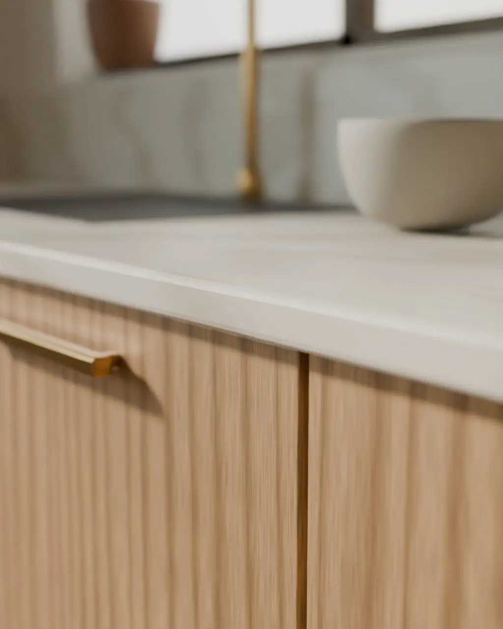 Concept render: the eased edge of the pale stone worktop above oak drawers