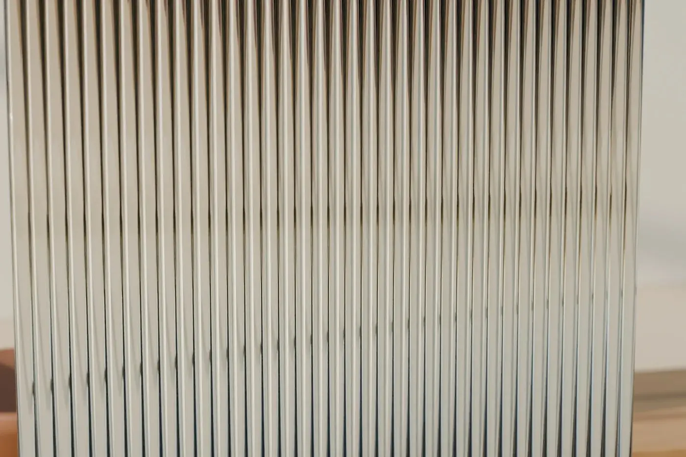 Concept render: a reeded glass panel on a brass foot, blurring the light behind it