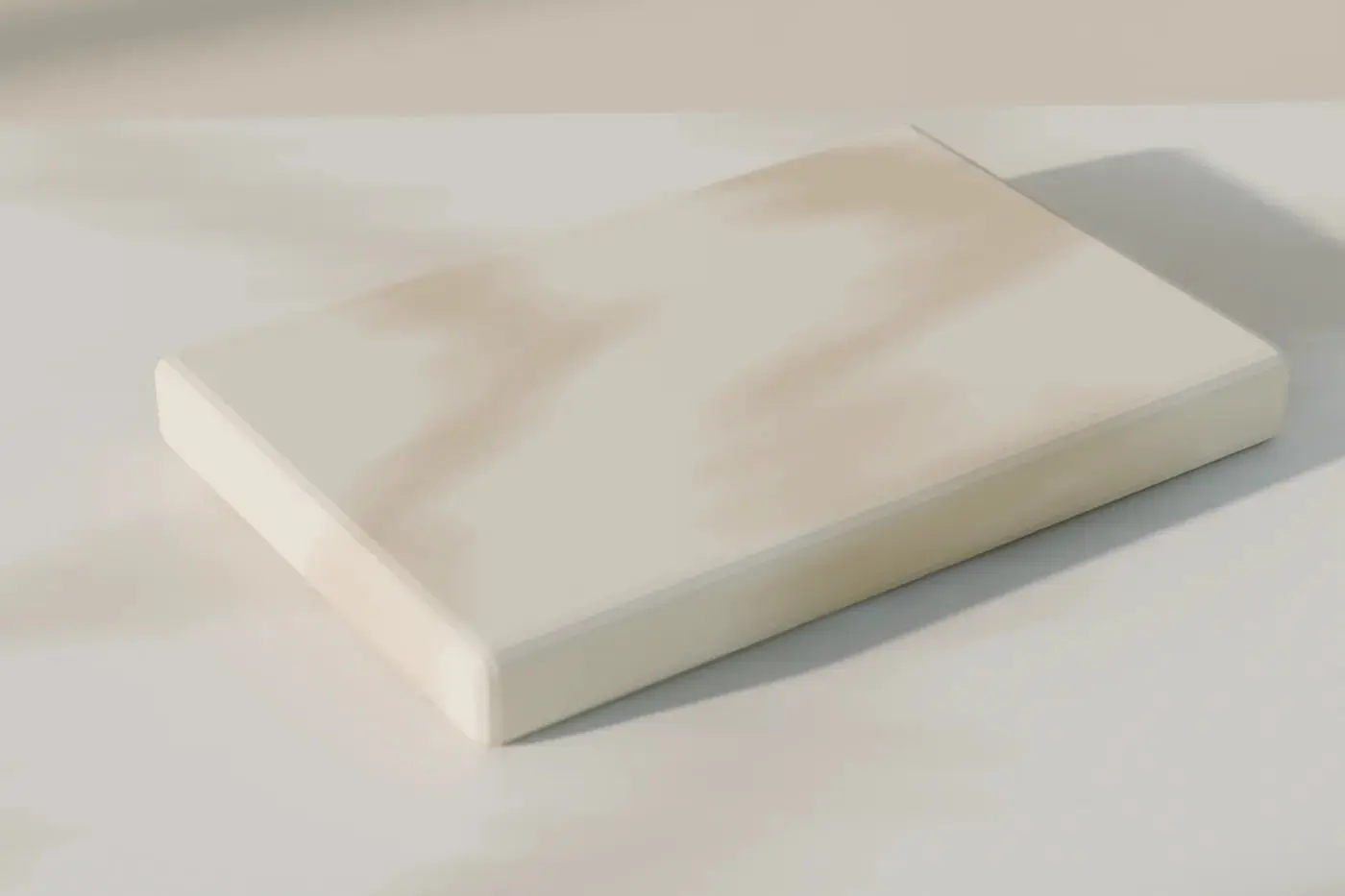 Concept render: a honed stone sample with an eased edge, resting on a pale worktop