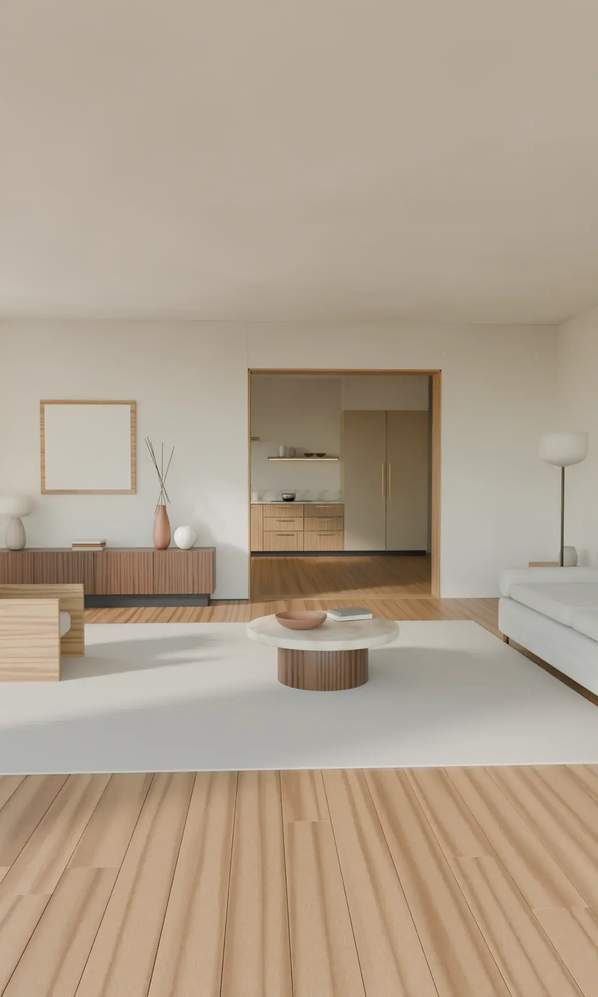 A calm living room in morning light: oak floor, a linen sofa, a stone table and a wide opening through to the kitchen