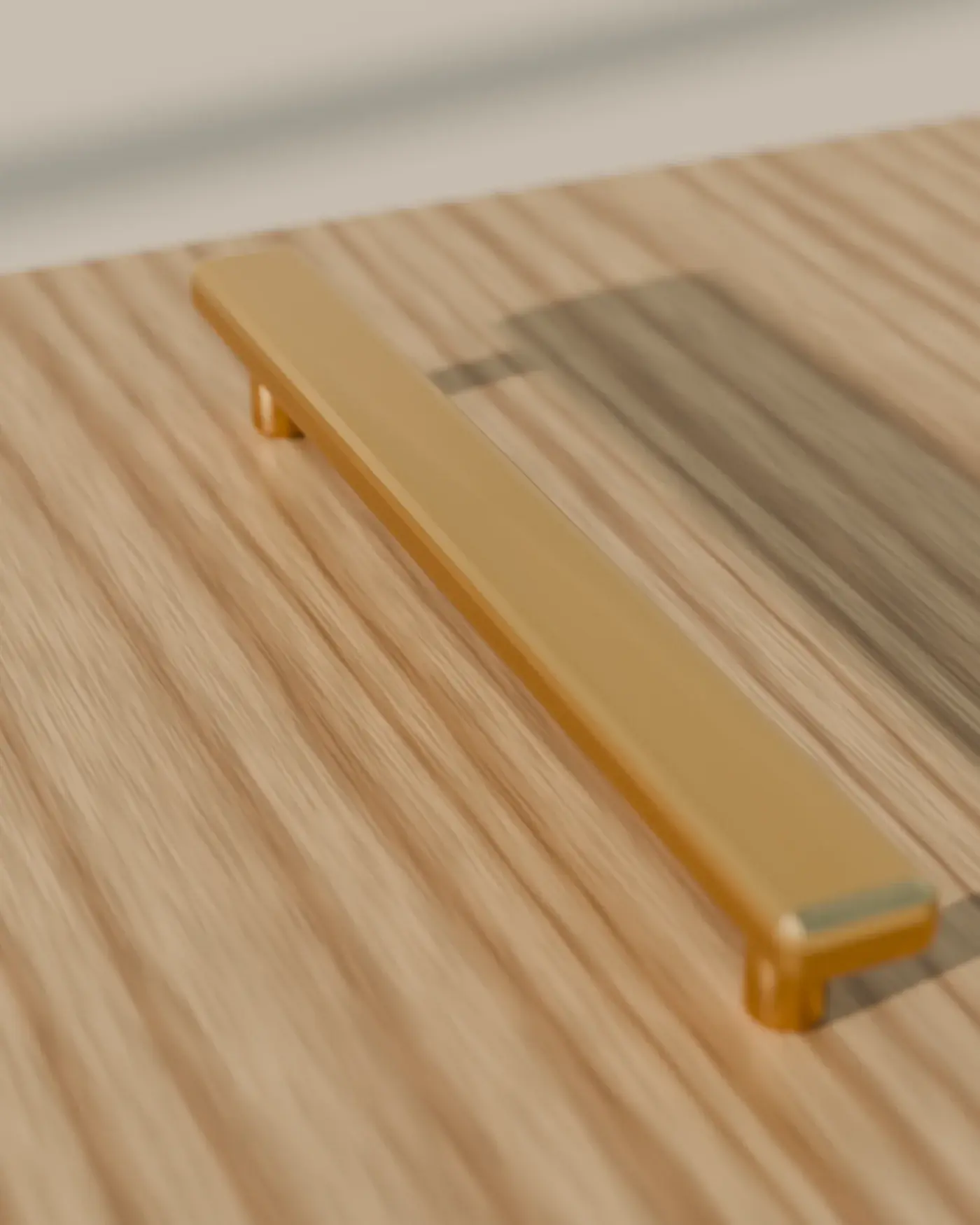 A brushed brass bar pull on an oak-veneered door